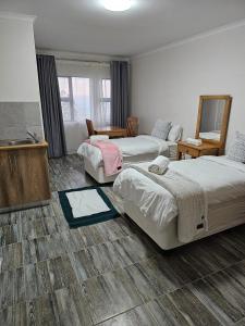 a hotel room with two beds and a table at HAGAR LODGE in Mid Illovo