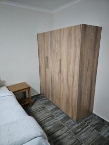 a wooden cabinet in a bedroom with a bed at HAGAR LODGE in Mid Illovo