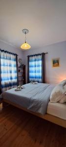 a bedroom with a large bed with two windows at Villa Sunset in Stoupa
