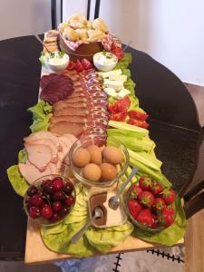 a platter of food on a table with meat and vegetables at Vujanac vikend kuća in Raška