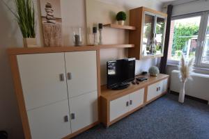 una camera con TV e armadio con televisore di 2020 Bungalow "Strandhüdde" a Dahme