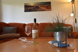una bottiglia di vino e un bicchiere su un tavolo di 2020 Bungalow "Strandhüdde" a Dahme