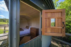 ヴェントナーにあるThe Hutのベッドと窓が備わる小さな客室です。