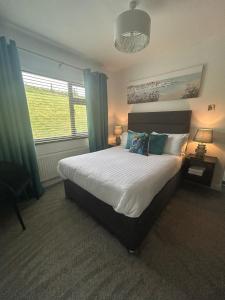 カラクローにあるRobin Hill Bed and Breakfastのベッドルーム1室(青いカーテン付きの大型ベッド1台付)