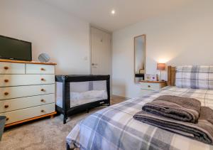 Somerdale في Ashwater: غرفة نوم مع سرير وخزانة مع تلفزيون