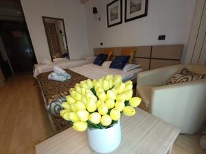 a room with two beds and a vase of flowers on a table at Vila Sangria in Mamaia Nord