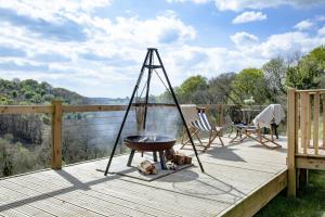 a grill on a deck with a dog laying next to it at Hawkings Hideaway in Knowstone