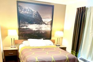 una habitación de hotel con una cama con una foto en la pared en Super 8 by Wyndham Hinton, en Hinton