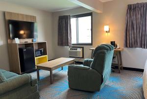 un soggiorno con divano e tavolo di Days Inn & Suites by Wyndham Des Moines Airport a Des Moines