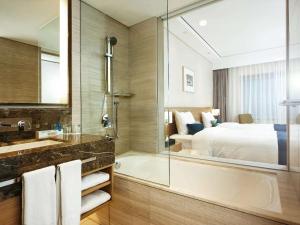 y baño con bañera, cama y ducha. en Novotel Ambassador Seoul Gangnam en Seúl