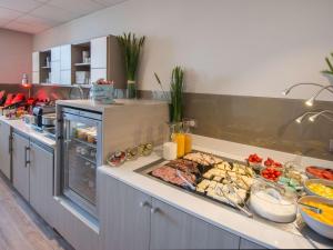 une cuisine avec un buffet de plats sur un comptoir dans l'établissement Mercure Nice Marché Aux Fleurs, à Nice