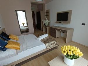a bedroom with a bed and a desk and a television at Vila Sangria in Mamaia Nord