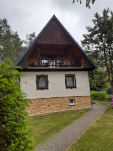 una casa con techo de gambrel y balcón en Chata Rynartice 7 en Jetřichovice
