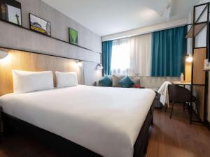 a large white bed in a hotel room at ibis Paris Gare de Lyon Diderot in Paris