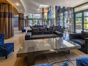- un salon avec des canapés et une table en verre dans l'établissement Hotel Parc Beaumont & Spa Pau - MGallery, à Pau
