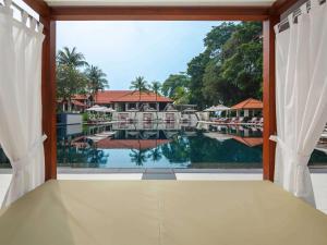 a view of the pool from a room with a window at Sofitel Singapore Sentosa Resort & Spa in Singapore
