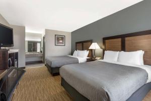 a hotel room with two beds and a flat screen tv at Quality Inn Gainesville in Gainesville +38 photos