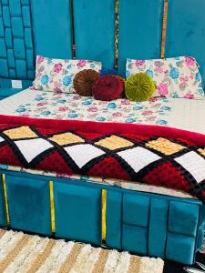 Una cama con mantas y almohadas coloridas. en POP Misba Homestay, en Bhadarwāh