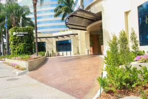 a walkway in front of a building with palm trees at Wyndham Garden Guayaquil in Guayaquil