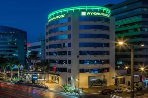a building with a green dome on top at night at Wyndham Garden Guayaquil in Guayaquil