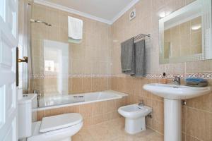 a bathroom with a toilet and a sink and a tub at MirAzul in Cumbre del Sol