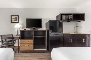 a hotel room with a refrigerator and a sink and a tv at Quality Inn Gainesville in Gainesville