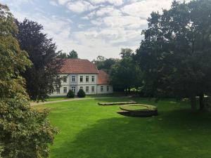 a large white house with a large yard with a grassy field at Parkhotel Cloppenburg in Cloppenburg