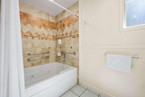 baño con bañera blanca y ventana en Econo Lodge Inn & Suites Heavenly Village Area, en South Lake Tahoe