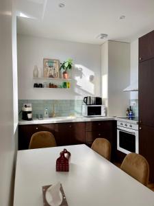 eine Küche mit einem weißen Tisch und einer Arbeitsplatte in der Unterkunft Montfaucon - Élégant appartement & terrasse au cœur de Bordeaux, idéalement situé in Bordeaux