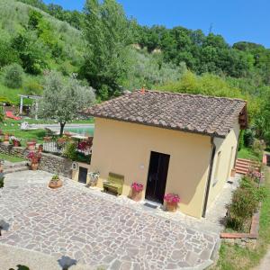 ein kleines gelbes Haus mit einer Steinterrasse in der Unterkunft Guest House Torre Guelfa in Figline Valdarno