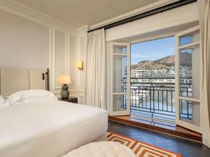 a bedroom with a bed and a large window at Cape Grace, A Fairmont Managed Hotel in Cape Town