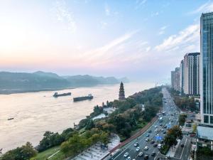 a city with a river and buildings and traffic at Grand Mercure Yichang Waitan in Yichang