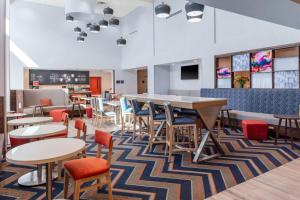 a dining room with tables and chairs and a bar at Hampton Inn & Suites Indianapolis West Speedway in Indianapolis