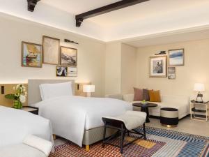 a bedroom with a large white bed and a couch at Sofitel Al Hamra Beach Resort in Ras al Khaimah