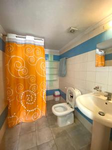 a bathroom with a shower curtain and a toilet at Olympia in Kfardebian