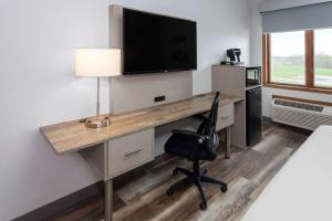 a room with a desk with a television and a chair at Links Bos Landen Hotel & Spa of Pella, Trademark by Wyndham in Pella