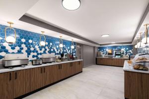 a large kitchen with blue and white tiles on the wall at Hawthorn Extended Stay by Wyndham Knoxville in Knoxville