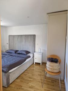 a bedroom with a large bed and a chair at Apartment Sidro in Poreč
