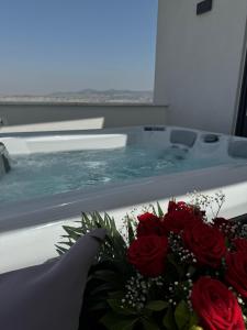 La salle de bains est pourvue d'une baignoire et d'un bouquet de roses. dans l'établissement SIGMA Luxury Apartments & Suites, à Thessalonique
