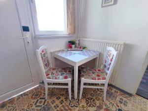 mesa pequeña con 2 sillas y mesa con mesa y sillas en Caesar Residence en Budapest