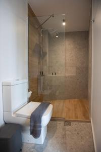 a bathroom with a toilet and a glass shower at Griffin Suites in Heraklio