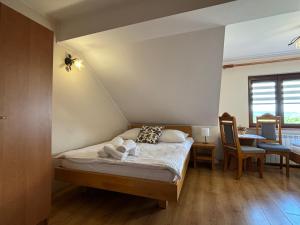 un dormitorio con una cama con dos animales de peluche en Agroturystyka u Ireny, en Mizerna
