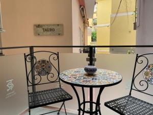 a small table and two chairs on a balcony at Taormina charming rooms in Taormina