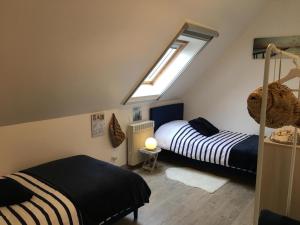 a attic bedroom with two beds and a skylight at Gite Les Azalées 8 personnes 10mn de Compiègne in Le Meux