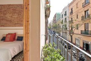a balcony with a bed and a street at Poble Sec Charming Apartment in Barcelona