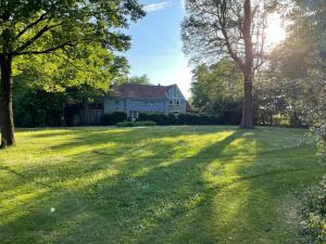 a house in the middle of a yard with trees at The Cottage in Merelbeke +7 photos