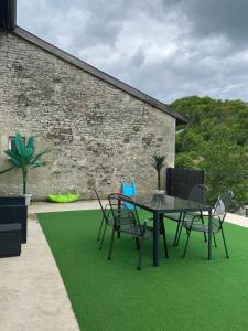 a patio with a table and chairs on grass at Chez Amandine in Osne-le-Val