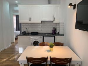 a kitchen with white cabinets and a table with chairs at Sabah Homes in Antalya