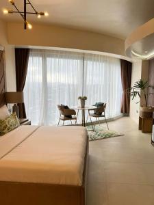 Aeon Towers Davao Condominium في مدينة دافاو: غرفة نوم بسرير وطاولة مع كراسي