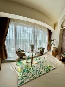 ein Wohnzimmer mit einem Tisch und Stühlen sowie einem großen Fenster in der Unterkunft Aeon Towers Davao Condominium in Davao City